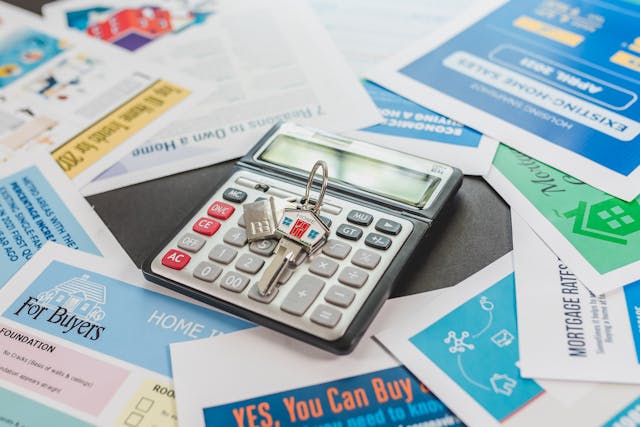 House keys and a calculator on top of documents for home buyers