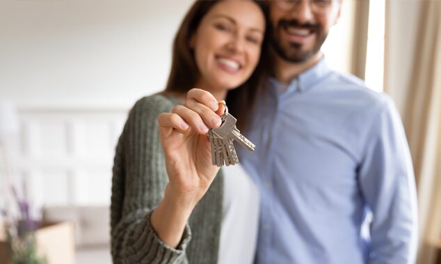 Family holding up keys to a property