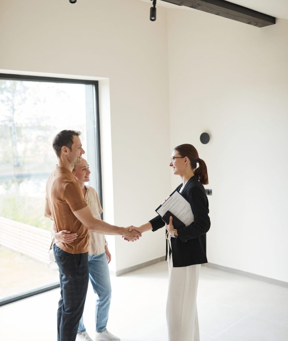 Vertical,Side,View,Portrait,Of,Young,Couple,Shaking,Hands,With people coming to an agreement in home