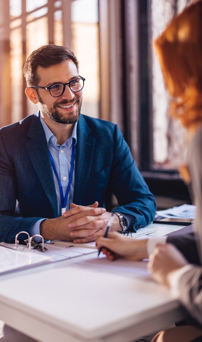 Property manager sitting down with a client to sign papers