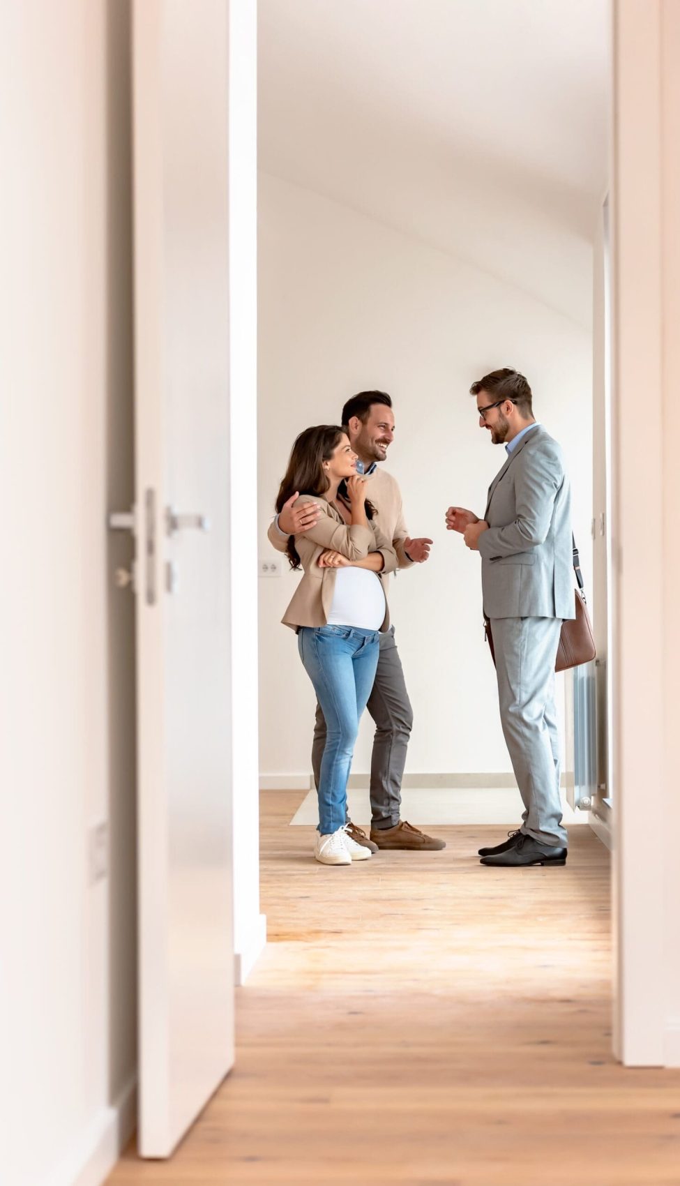 Young,Married,Couple,Talking,With,A,Real-estate,Agent,Visiting,Apartment Young couple signing papers on a property